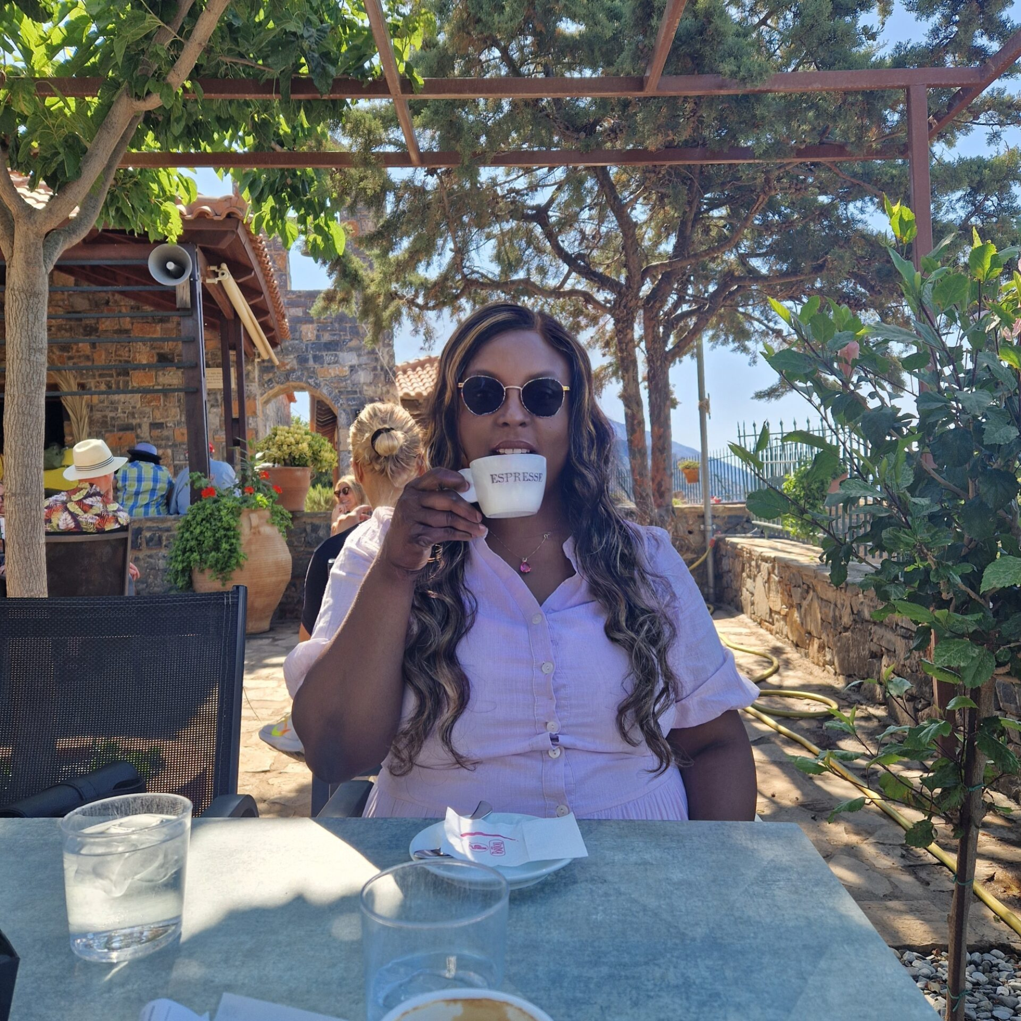 Woman enjoying an espresso outdoors, symbolising calm confidence and future vision.
