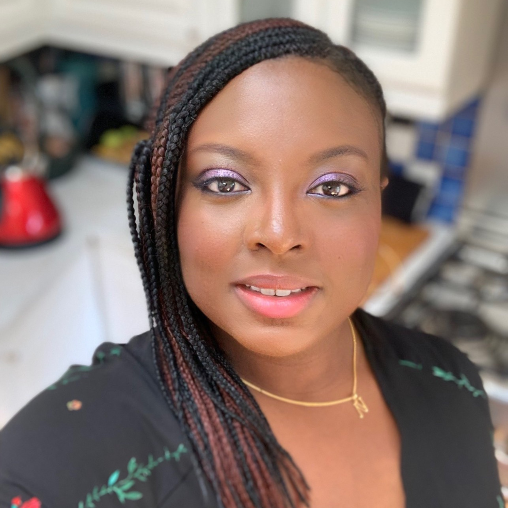 Close-up portrait of a Nefe with braided hair and soft makeup, taken indoors.