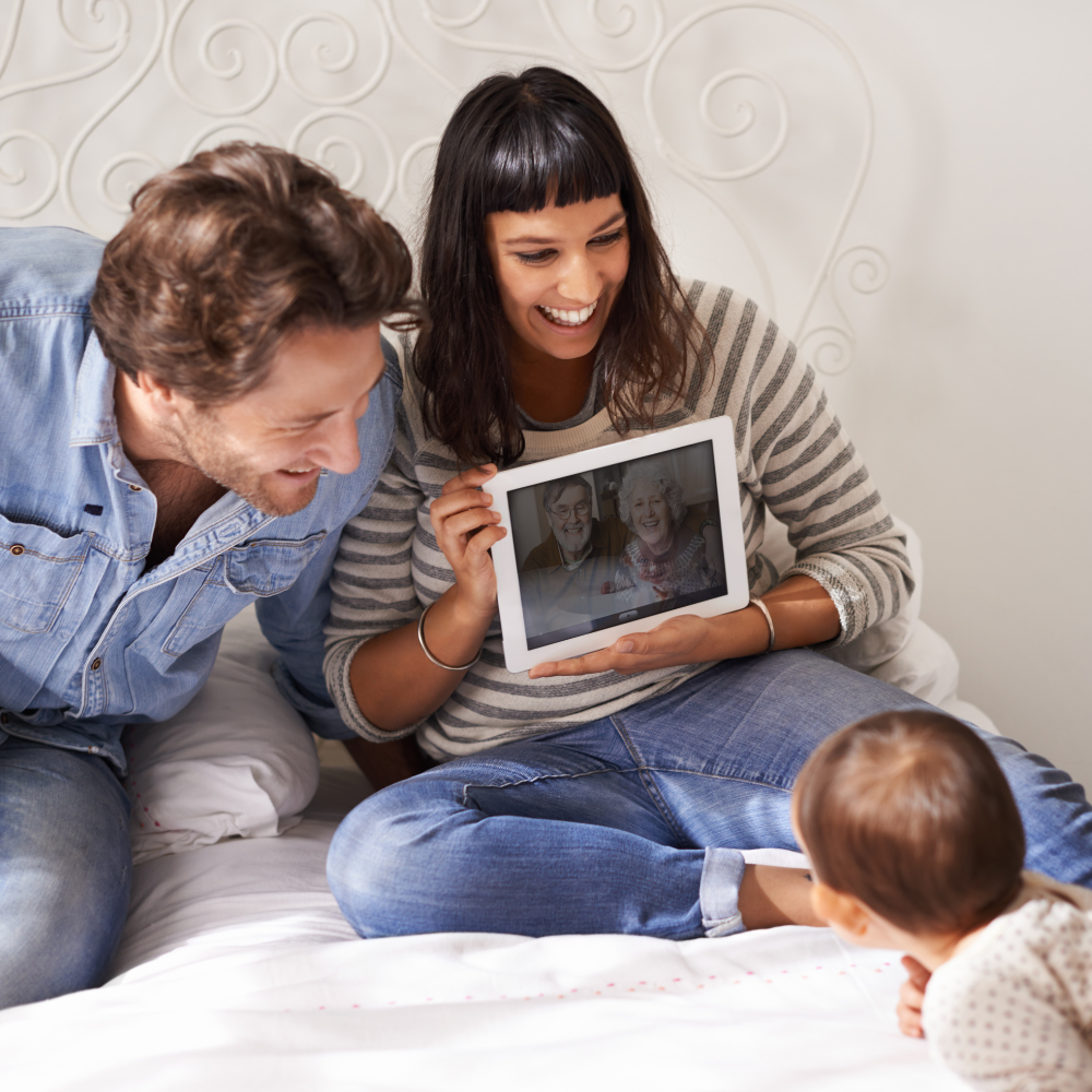 Building Stronger Connections A Complete Manual Young family video calling with grandparents showing a toddler the screen of a tablet