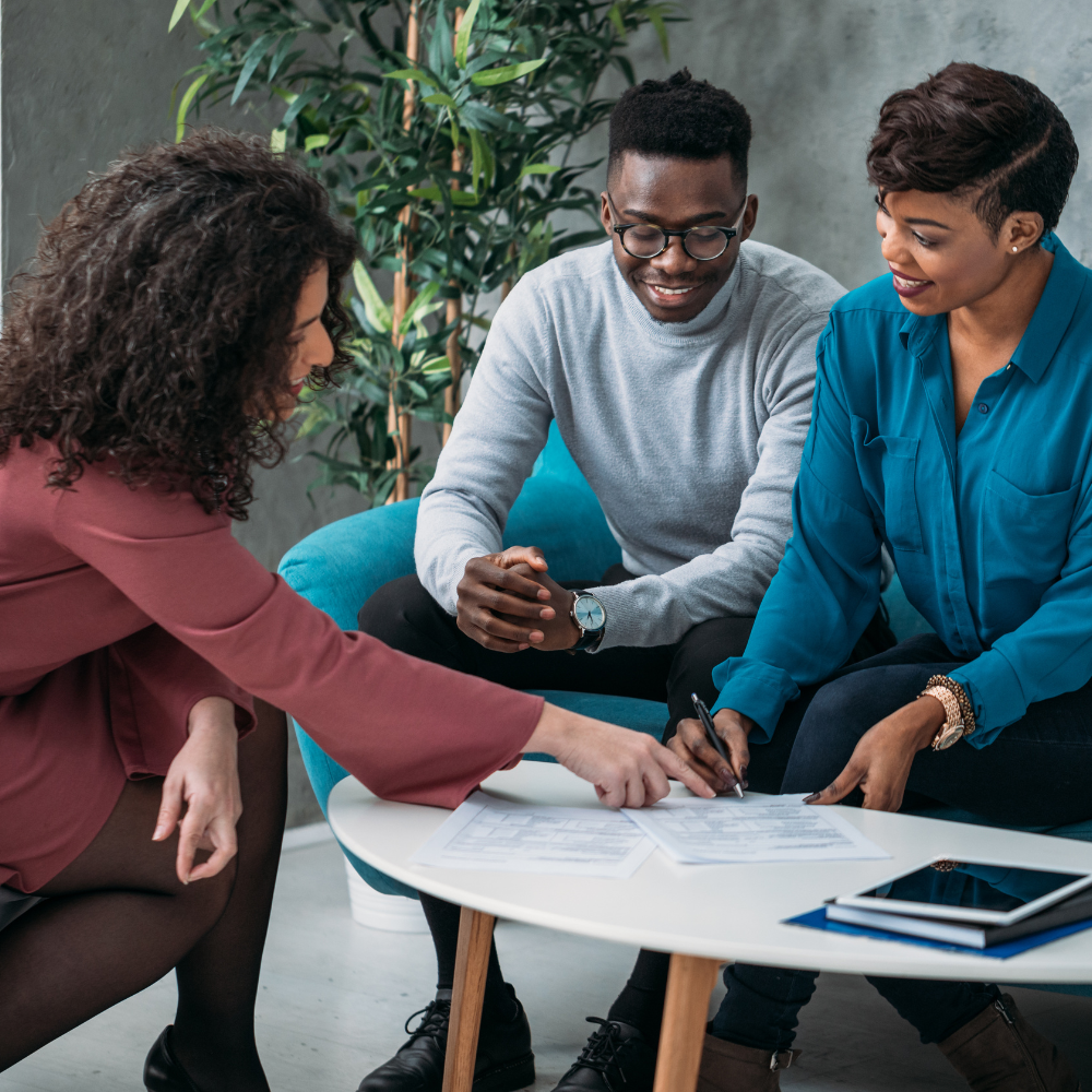 14 Navigating Financial Stress Tips and Strategies to Manage Your Finances A financial advisor guiding a couple through financial planning, sitting together at a table with documents.