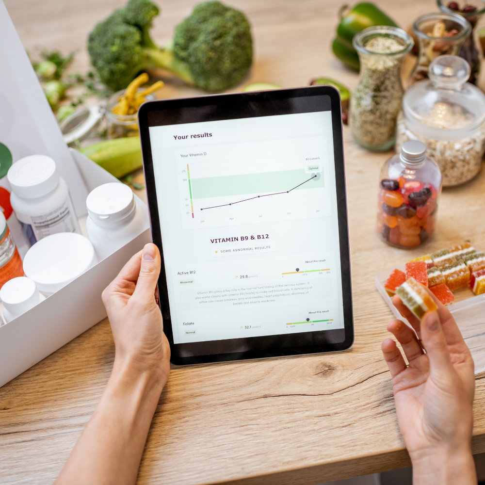 17. Essential Nutrition Tips for Busy Professionals Person reviewing nutrition and vitamin results on a tablet surrounded by healthy foods and supplements.