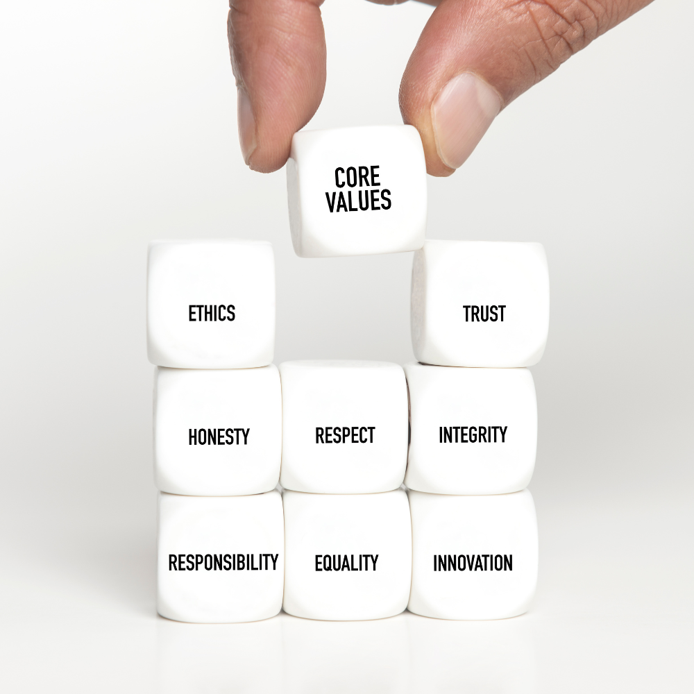 42. Aligning with Your Values Making Every Decision Count A person’s hand stacks white cubes labelled with concepts like “Core Values,” “Ethics,” and “Trust.”