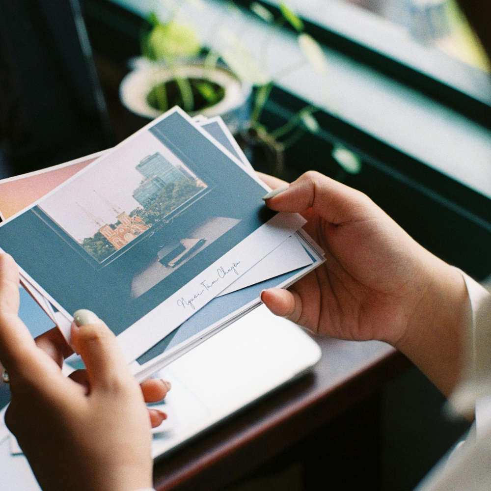 Hands holding a photo print near a window, symbolising reflection and creating a post-summer self-love roadmap.