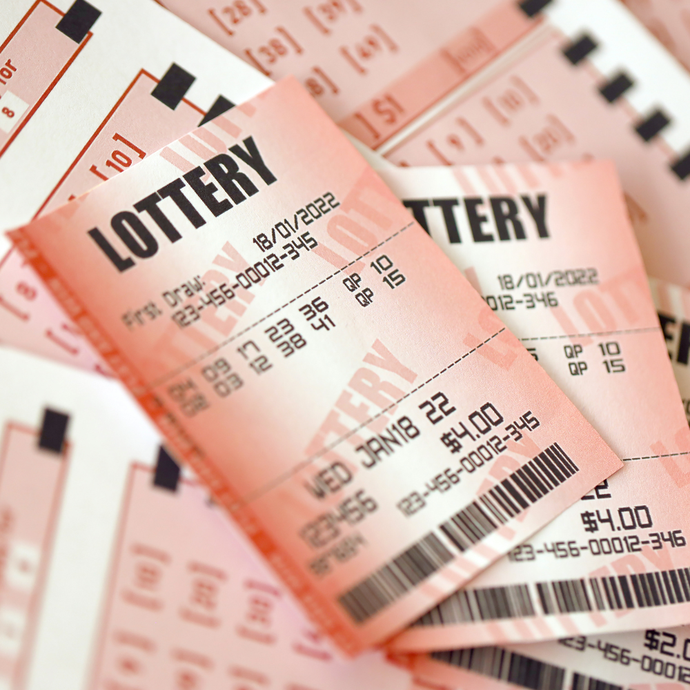 Close-up of pink lottery tickets with printed numbers and barcodes, representing the dream of winning big.